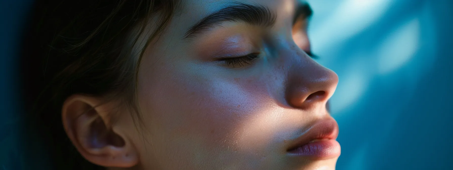 a person undergoing emdr therapy, with eyes closed and enveloped in a calming blue light, as they work towards unraveling deep emotional wounds.