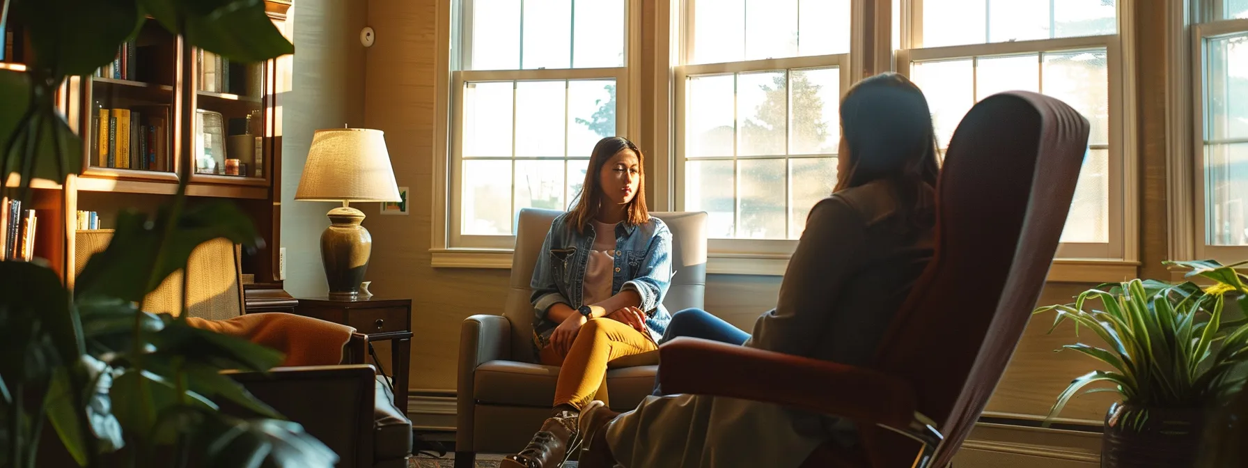 a person sitting across from a compassionate therapist in a cozy office, discussing their mental health journey and treatment options.