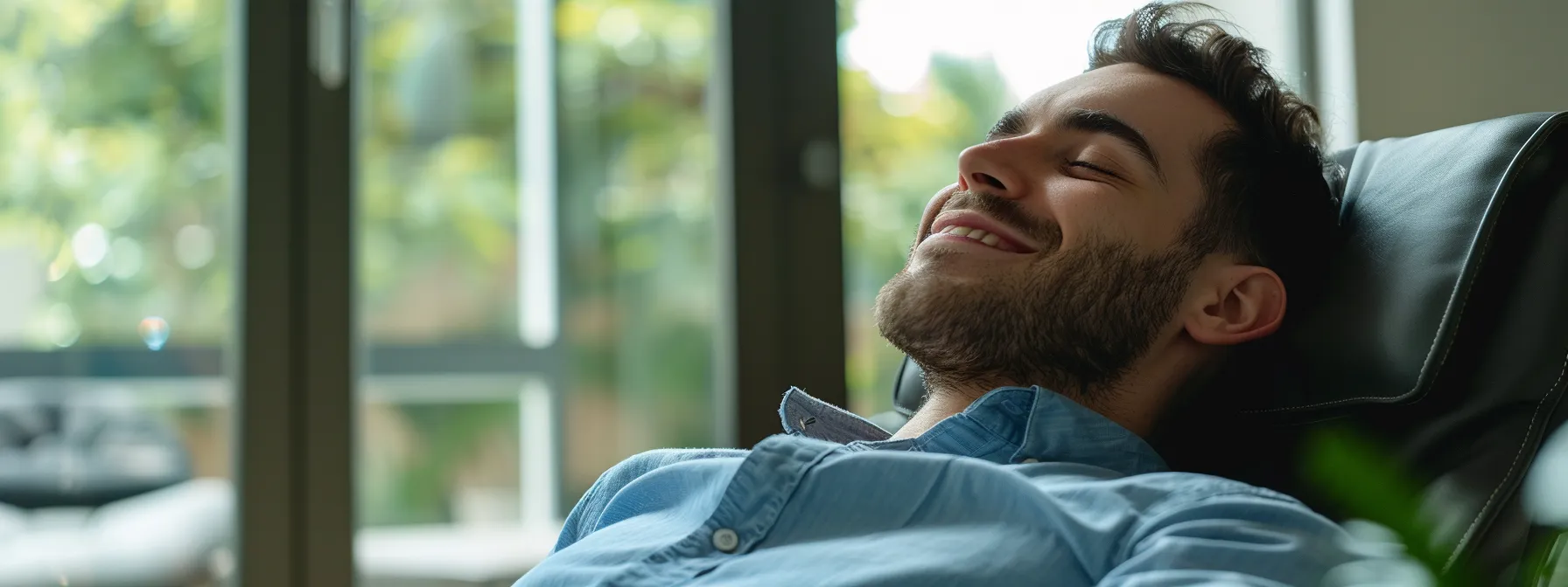 a man with a smile of relief on his face, sitting comfortably in a chair while engaging in a cognitive behavioral therapy (cbt) session.