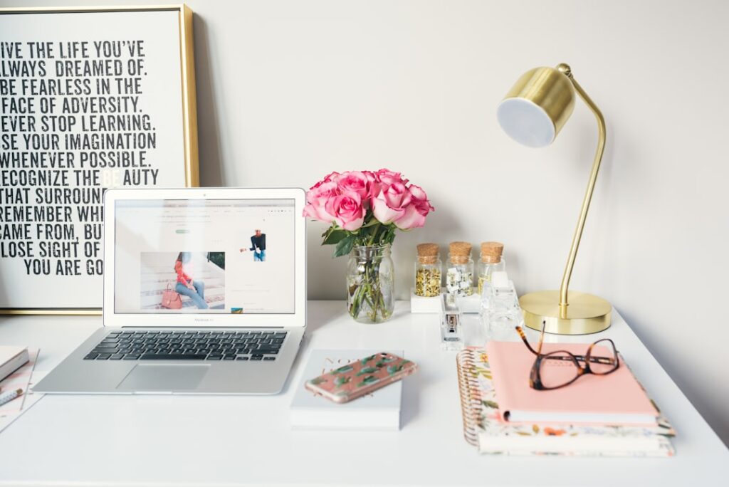 Organized desk with a laptop, flowers, and motivational quote, suggesting coping strategies for PTSD.